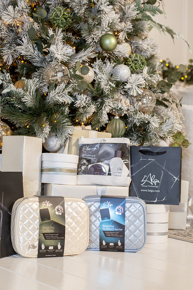 a group of gift boxes with hair care products under the christmas tree